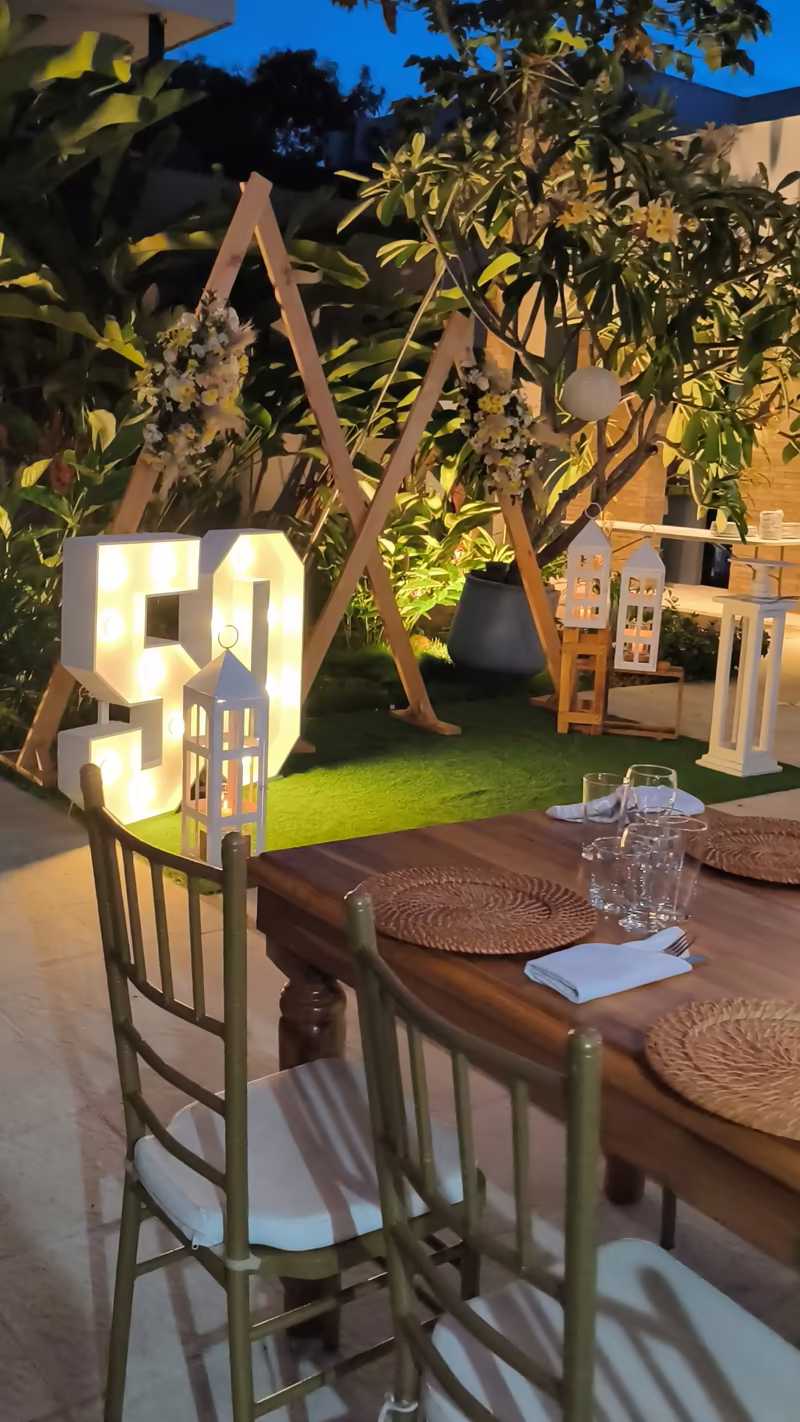 Letras iluminadas junto a una mesa montada con cristalería