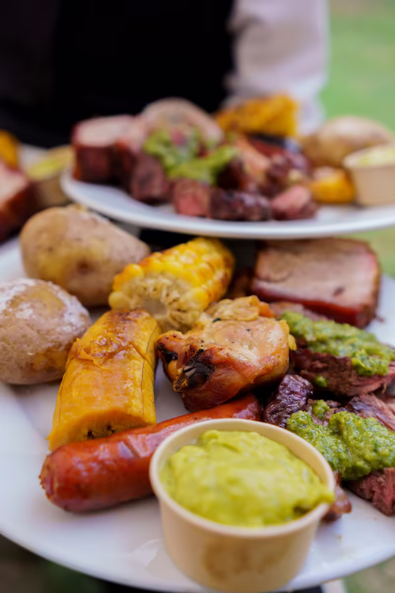 Plato servido con cortes de carne, papas criollas, mazorca y guacamole