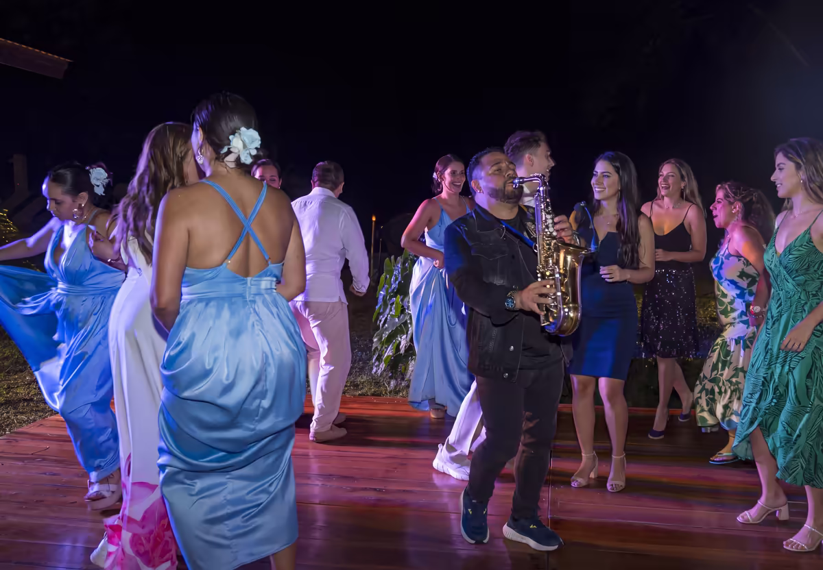 Invitados bailando mientras un saxofonista toca en vivo