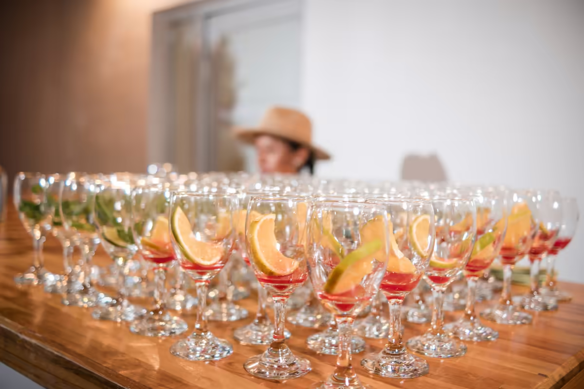 Copas de coctel con rodajas de naranja alineadas en la barra