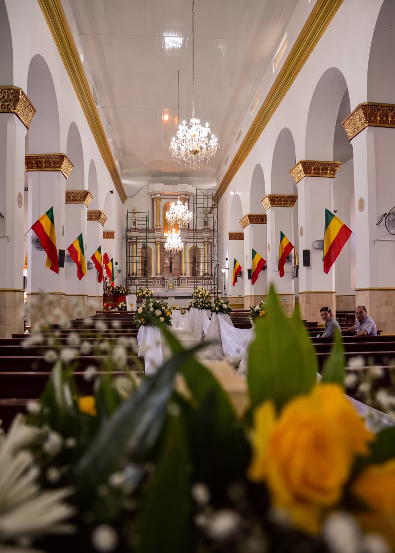 Interior de la iglesia decorado para una boda, con un arreglo de rosas en primer plano