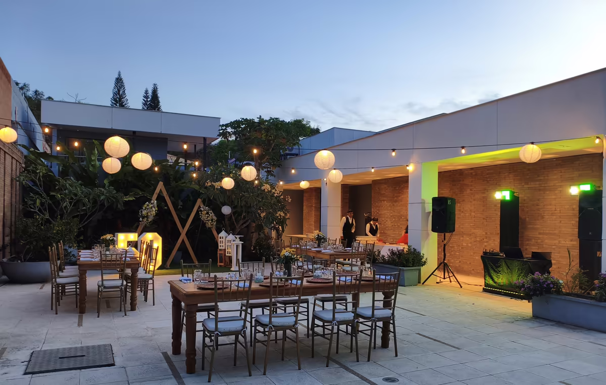Patio con farolillos encendidos y mesas montadas al caer la noche