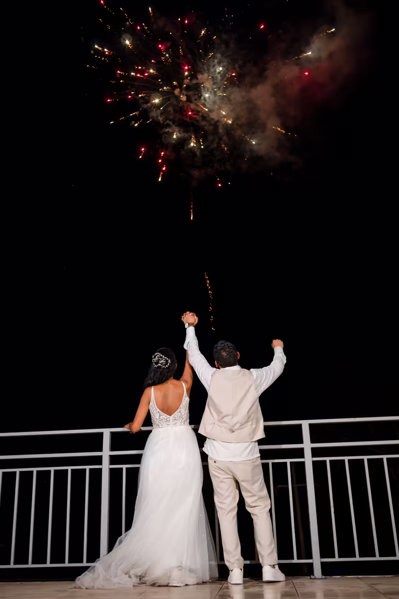 Pareja de novios de espaldas viendo los fuegos artificiales al cierre de la celebración