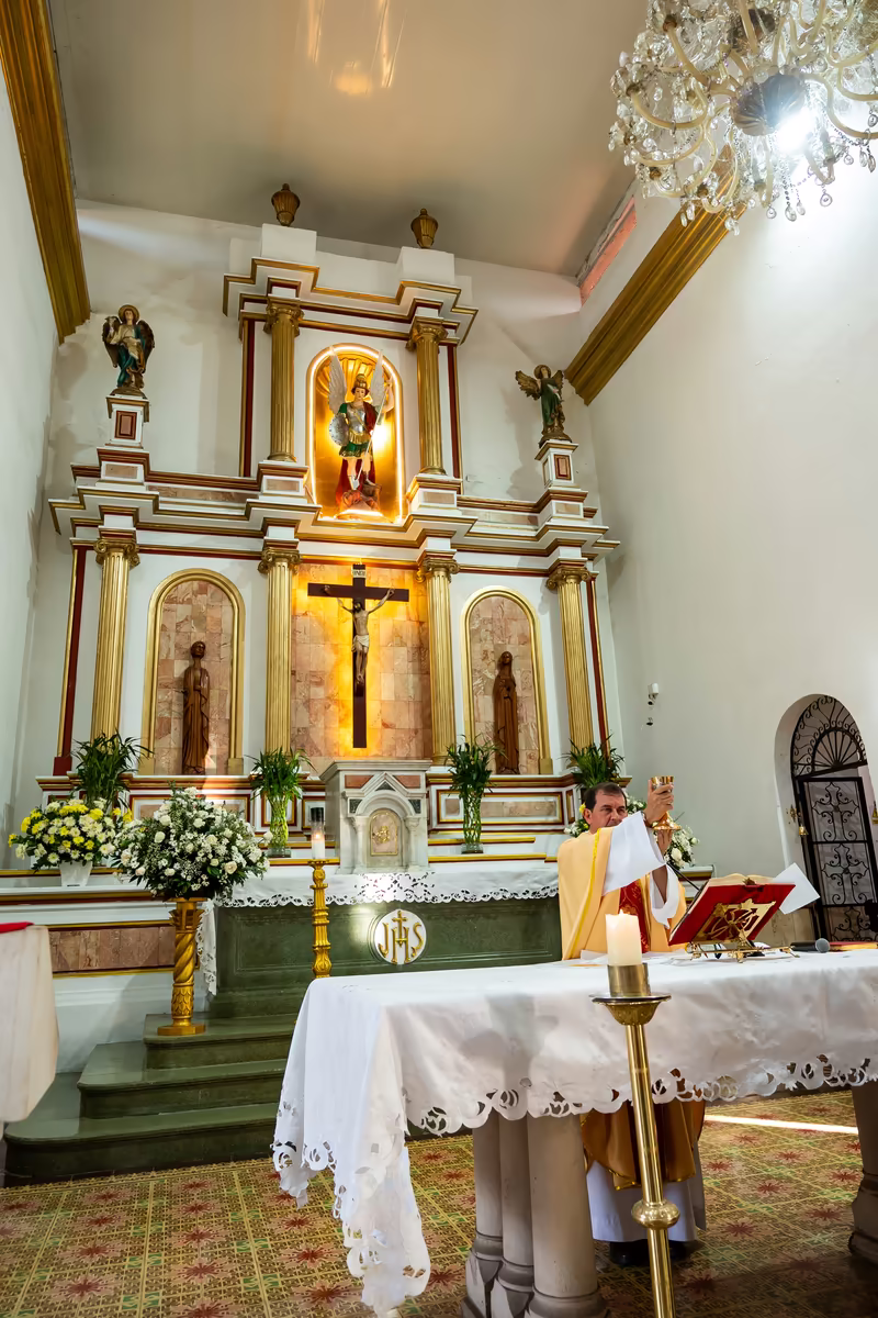 Altar de la iglesia decorado con arreglos florales blancos durante la ceremonia de matrimonio