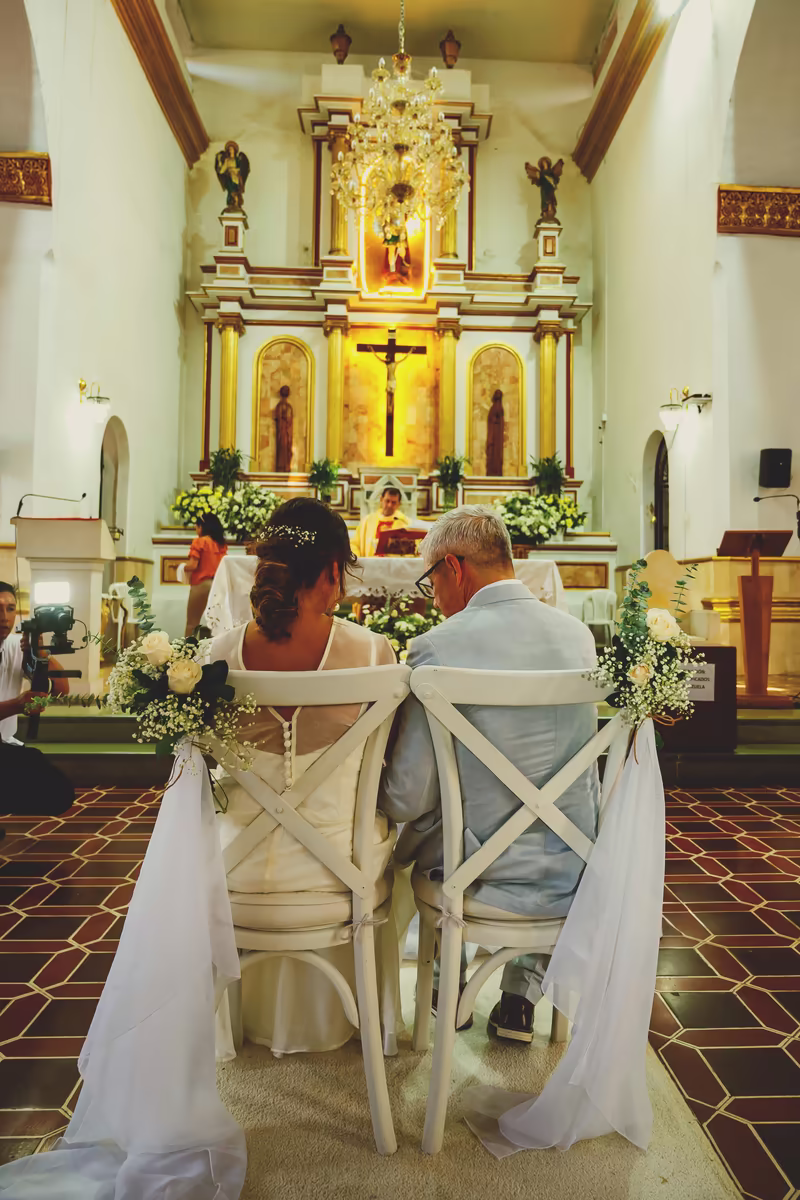 Los novios sentados frente al altar durante la ceremonia religiosa