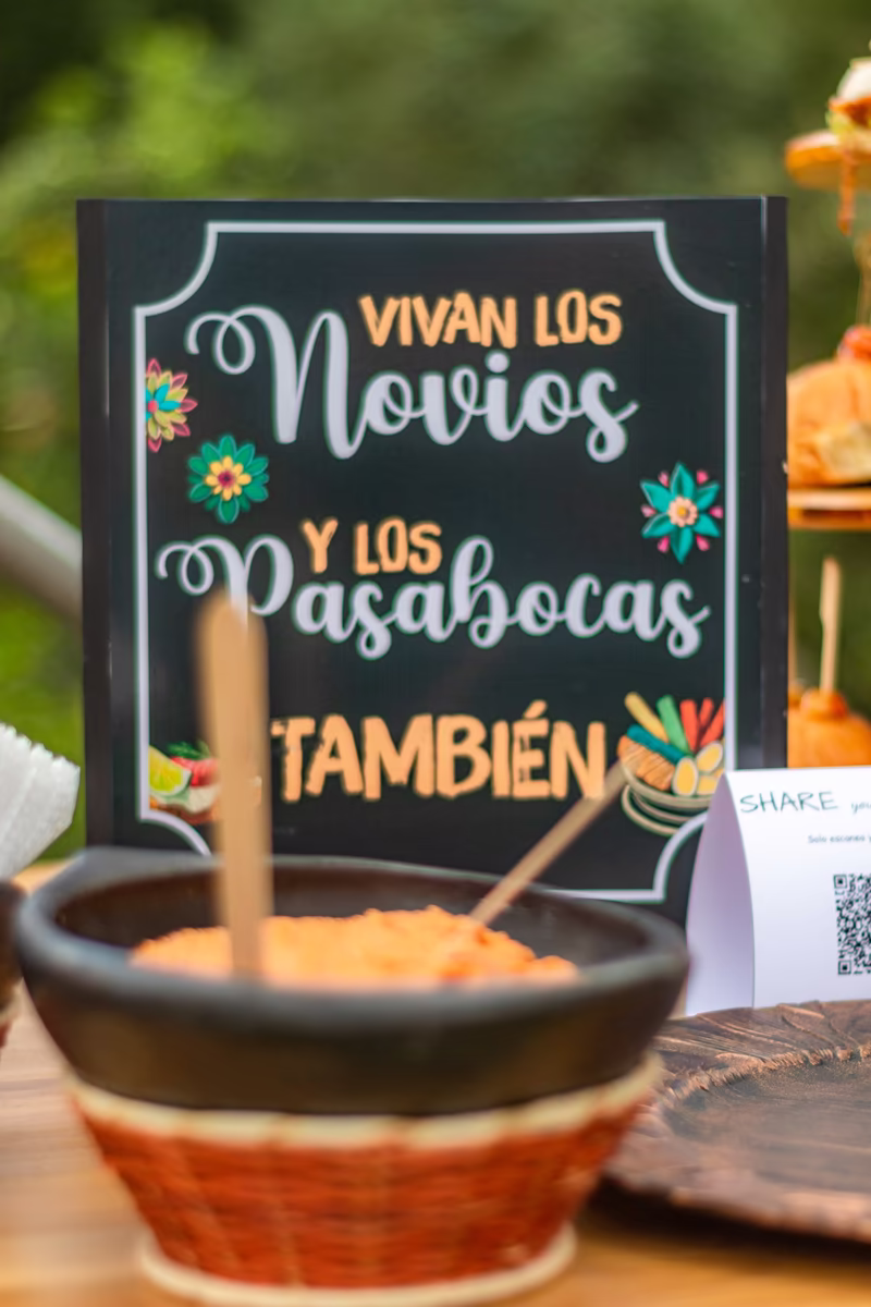 Letrero de pizarra que dice «Vivan los novios y los pasabocas también» en la mesa de picar