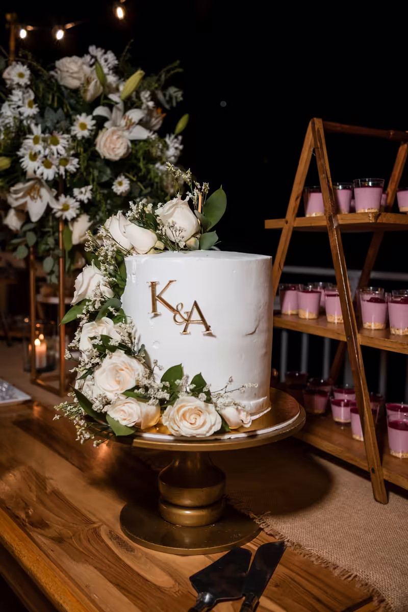 Torta de boda blanca personalizada con las iniciales de los novios y flores naturales