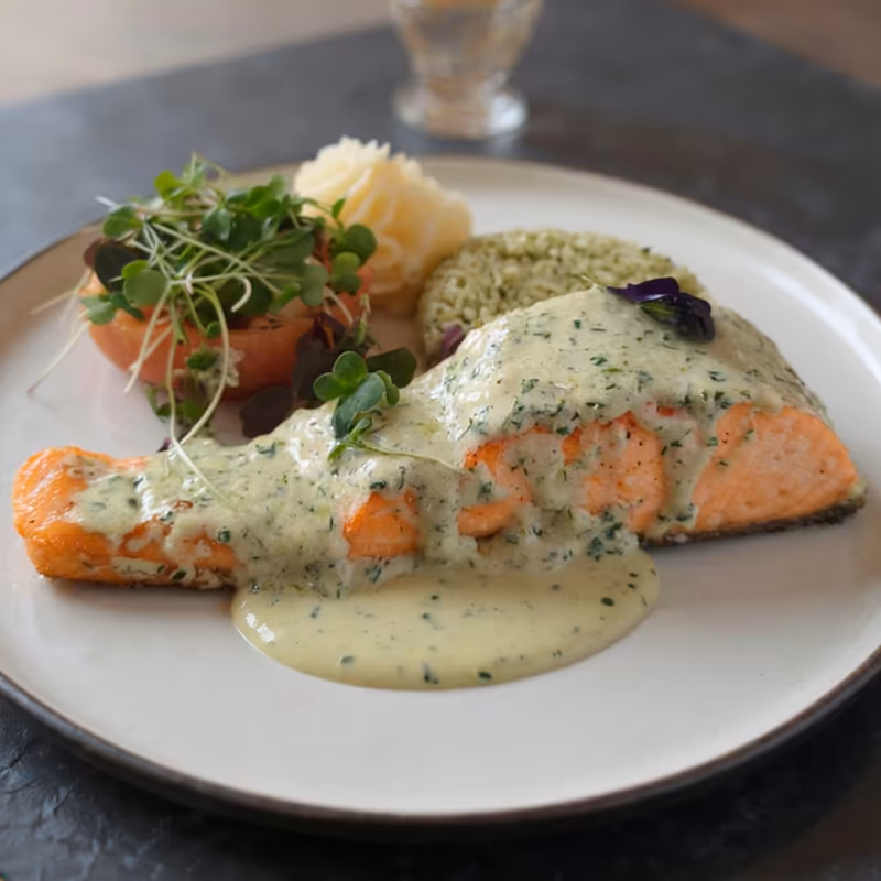 Salmón con salsa blanca de hierbas, arroz verde, puré y tomate relleno