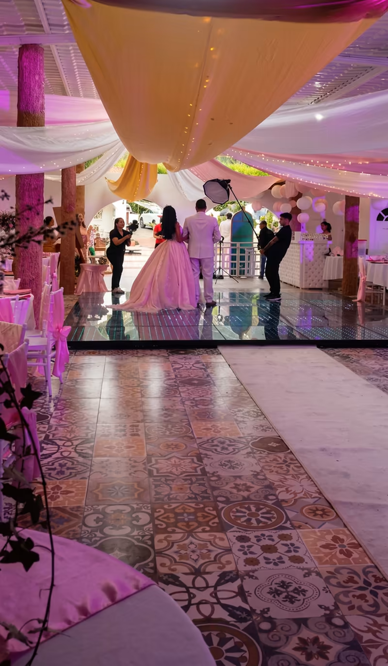 Padre e hija bailando el vals, vistos desde el camino de entrada al salón