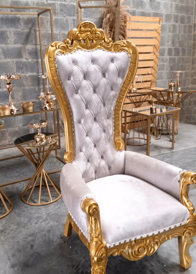 Silla tipo trono en dorado y blanco montada como punto de fotografías