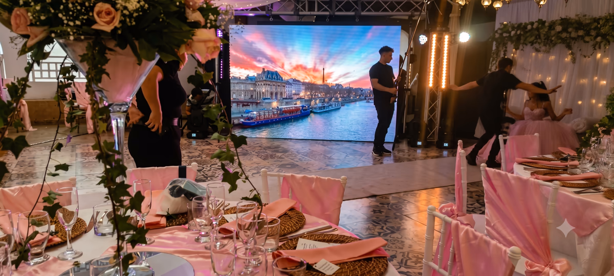 Pantalla con un paisaje al atardecer montada como fondo de fotografías del evento